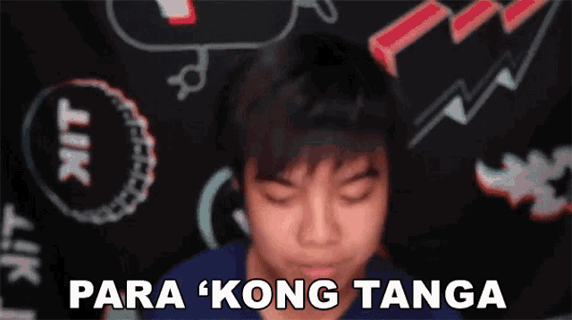 a young boy is making a funny face with the words para kong tanga behind him .
