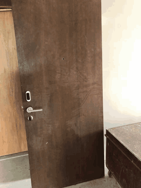 a wooden door with a stainless steel door handle