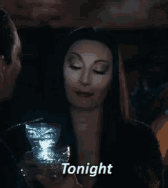 a woman is holding a glass with the word tonight written on it