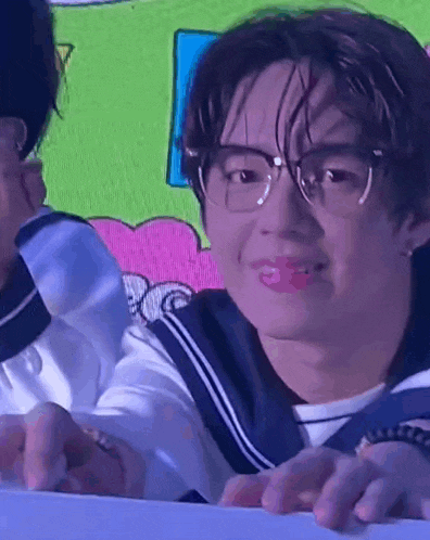 a close up of a person wearing glasses and a sailor suit .