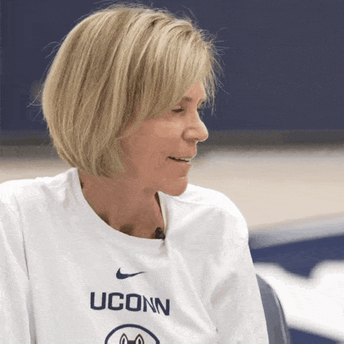 a woman wearing a white uconn shirt