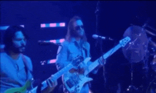 two men are playing guitars and singing on a stage