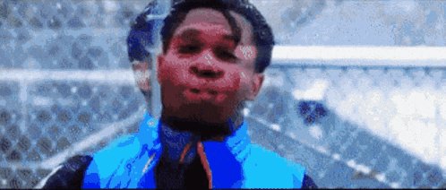 a man with blood on his face is wearing a blue jacket