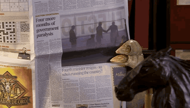 a newspaper that says four more months of government paralysis on it