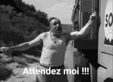 a man in a tank top is standing in front of a truck with the words attendez moi !!!