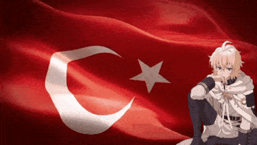 a man sitting in front of a flag with a crescent moon and star