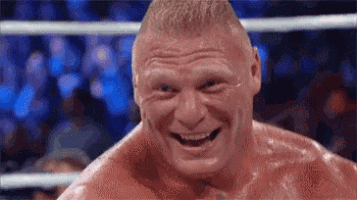 brock lesnar is smiling while standing in a boxing ring in front of a crowd .