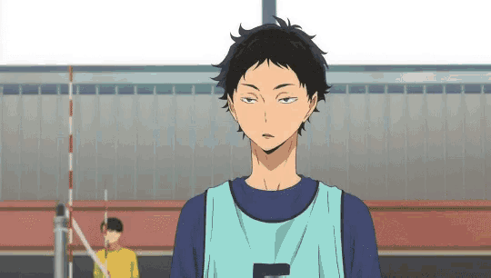 a man is standing in front of a volleyball net .
