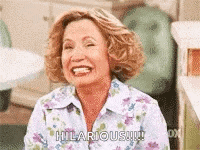 a woman in a floral shirt is smiling and laughing .