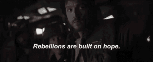 a man is sitting in a dark room with the words rebellions are built on hope written above him .