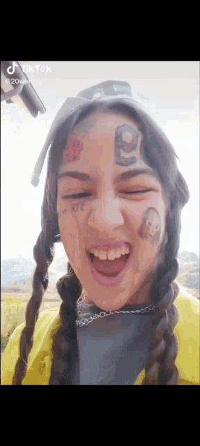 a woman with a tattoo on her face is smiling