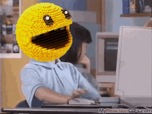 a person sitting at a desk with a yellow smiley face on their head