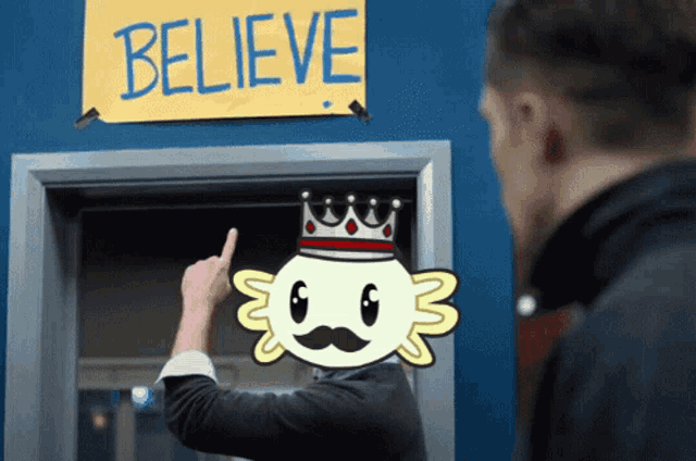 a man pointing at a sign that says " believe "