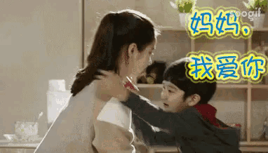 a boy is hugging a woman in a kitchen with chinese writing on it