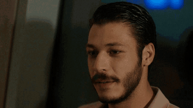 a man with a beard and mustache is looking down