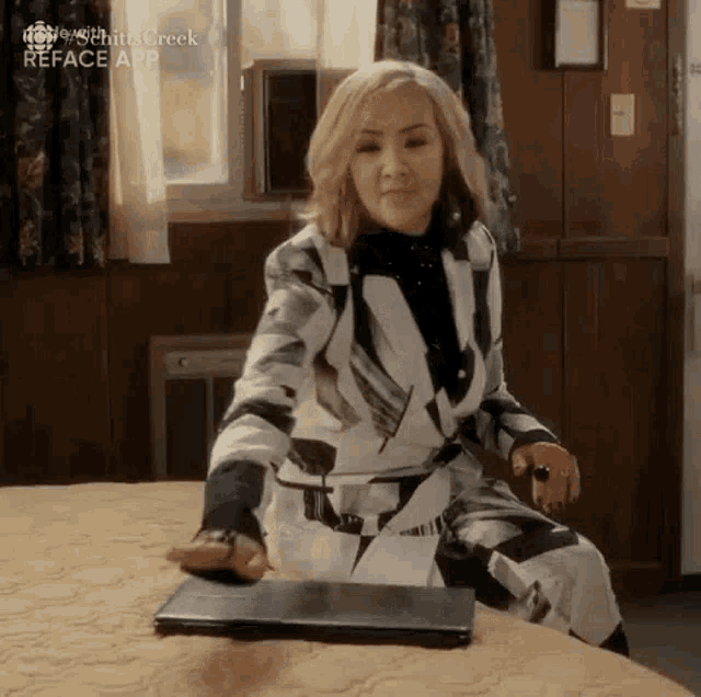 a woman is sitting on a bed with a laptop on it .