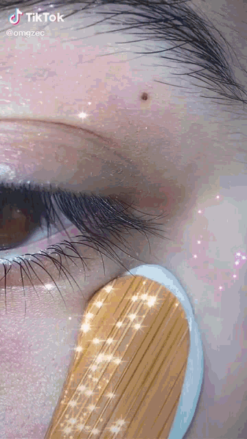 a close up of a woman 's eye with a wooden stick in it