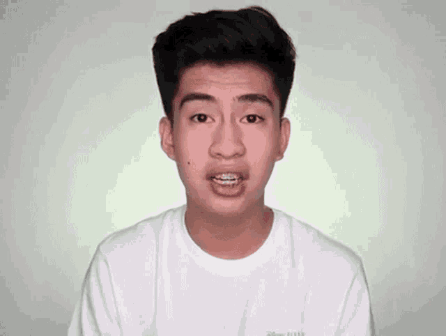 a young man with braces on his teeth is making a funny face .