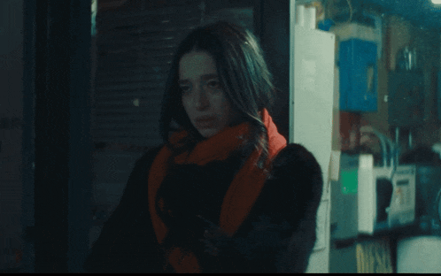 a woman smoking a cigarette in front of a sign which says diesel