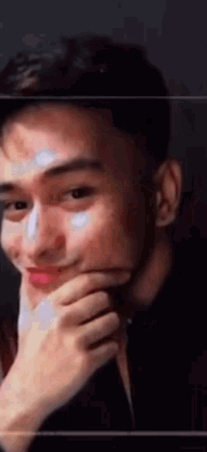 a man with his hand on his chin is smiling .