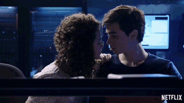 a man and woman are kissing in front of a netflix logo