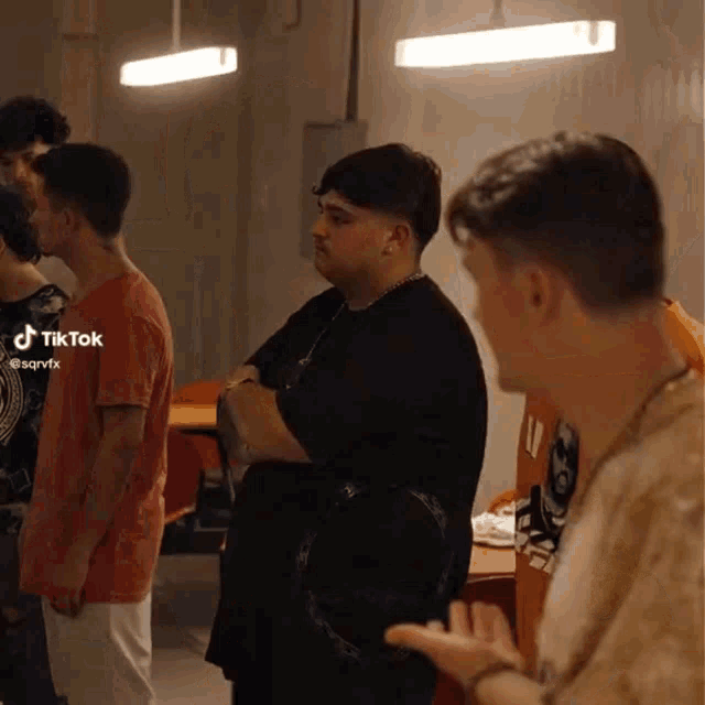 a group of young men are standing in a room with tiktok written on the bottom right corner