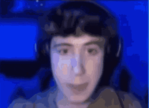 a blurry picture of a man wearing headphones and looking at the camera .