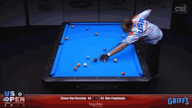 a man is playing pool in front of a screen that says griff 's on it