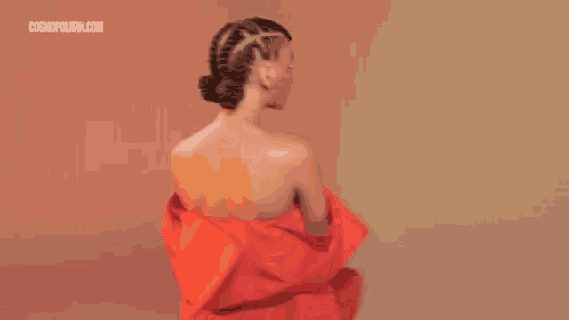 a woman with braids is wearing a red jacket and a red dress .