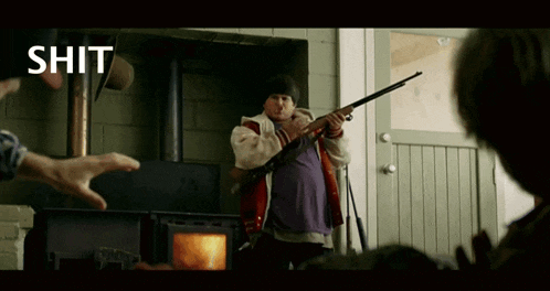 a man is holding a shotgun in front of a fireplace with the word shit above him