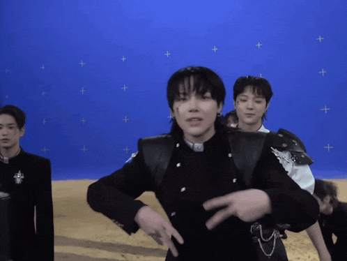 a group of young men are standing in front of a blue screen
