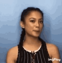 a woman is wearing a striped tank top and braids .