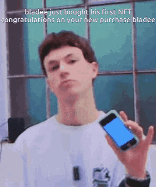 a man is holding a cell phone with a blue screen and congratulations on your new purchase bladee
