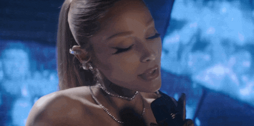 a woman wearing a choker and earrings holds a microphone