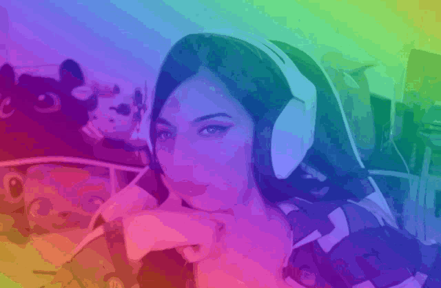 a woman wearing headphones is sitting in front of a rainbow background