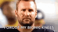 a man with a beard is looking at the camera with the words `` forgot my bionic knees '' written below him .