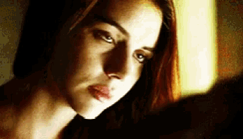a close up of a woman 's face with a dark background