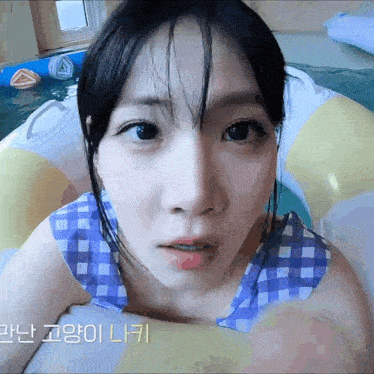 a close up of a woman 's face in a pool with foreign writing on the bottom