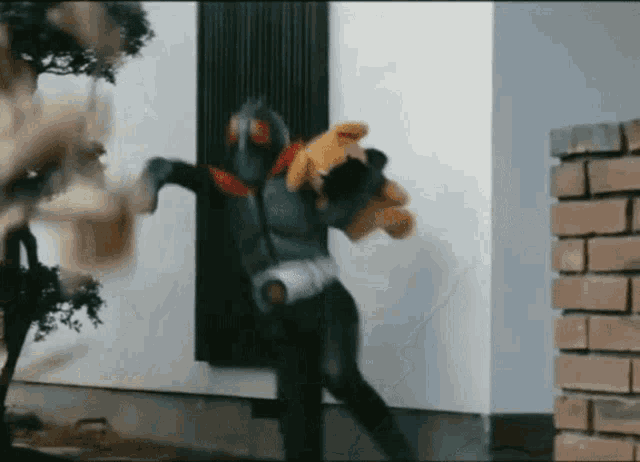 a man in a superhero costume holding a teddy bear