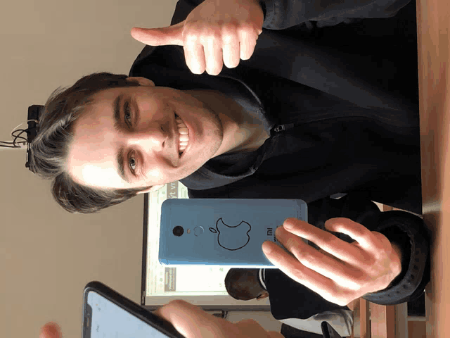 a man is holding a cell phone that says mi on it