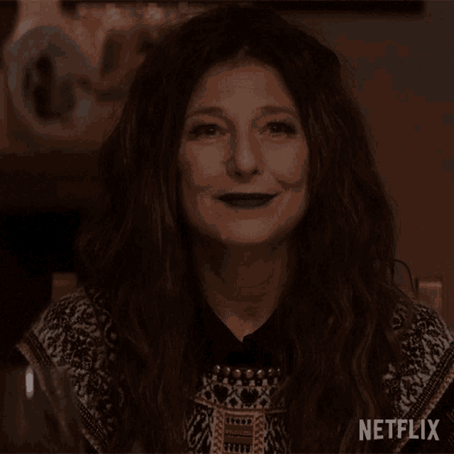 a woman is smiling with a netflix logo in the corner of her face