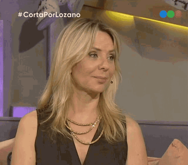 a woman sitting on a couch with # cortaporlozano on the bottom