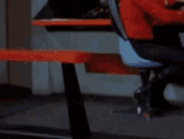 a man in a blue shirt is making a funny face while sitting at a table .