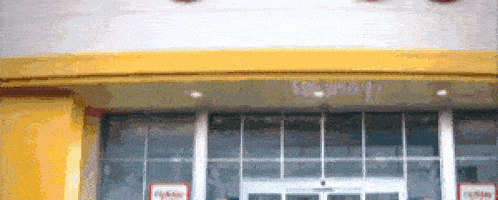 a store front with a yellow awning and a sign that says holiday