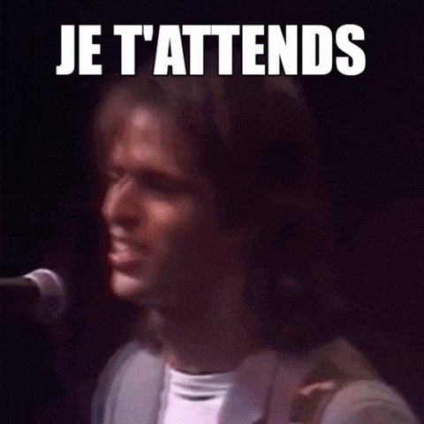 a man singing into a microphone with the words je t'attends on the bottom