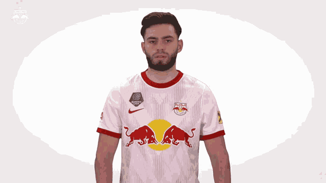 a man wearing a white red bull jersey stands in front of a white background