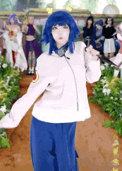 a woman in a blue wig is standing in front of a group of people in a garden .