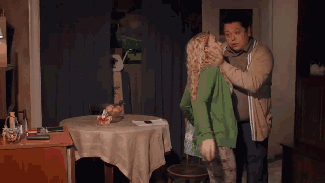 a man holds a woman 's neck in a dark room