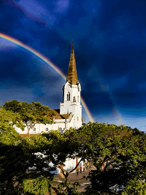 a church with a rainbow in the sky