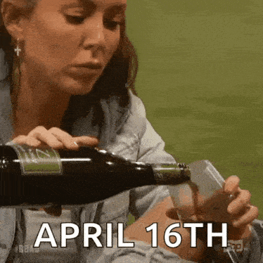 a woman is pouring a bottle of wine into a glass while holding a cell phone .